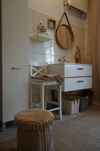 a bathroom with a sink and a stool and a mirror at Thula - Apartment in Villa Ambrosian in Trzebież