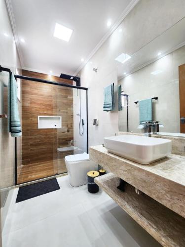 a bathroom with a sink and a toilet and a shower at Casa para 4 pessoas I Churrasqueira I Garagem para 2 carros I 5min do centro in São Lourenço