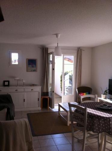 sala de estar con mesa y cocina en La Paloma, en Aigues-Mortes