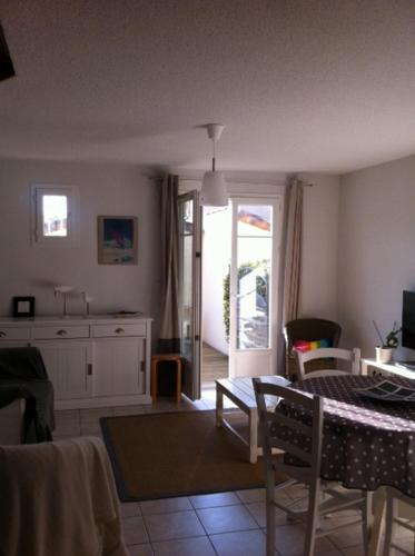 a living room with a table and a kitchen at La Paloma in Aigues-Mortes