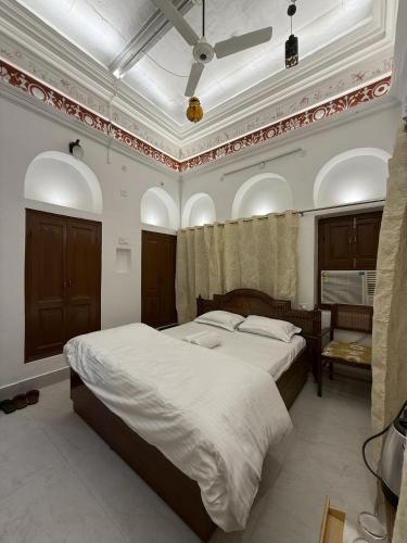 a bedroom with a large bed and a ceiling at Rudreshwar Mahadeo Kothi in Varanasi