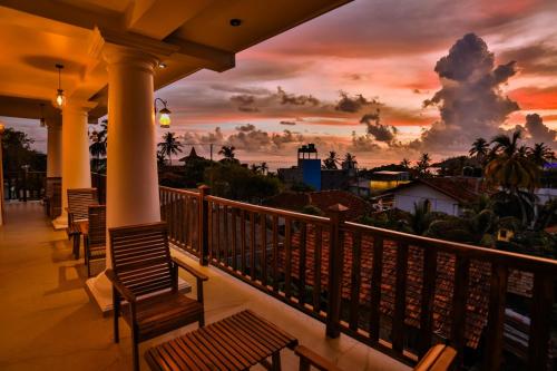 a balcony with a view of a sunset at King Palace Mirissa in Mirissa