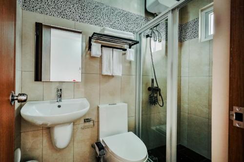 a bathroom with a sink and a toilet and a shower at Kabesera Bed and Coffee in Binangonan