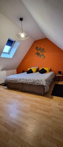 a bedroom with a bed with an orange wall at Gîte Côte et Terre in Questrecques