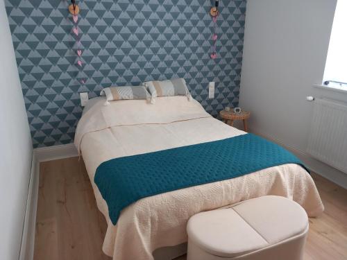 a bedroom with a bed and a stool in it at A la ferme chez Christian in Escaudoeuvres