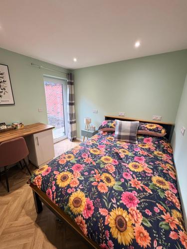 a bedroom with a bed with a floral bedspread at Clover Road Guest Suite in Swaffham