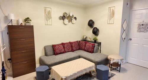 a living room with a couch and a table at J&J Antipolo Place 2BR with Netflix & Karaoke in Antipolo