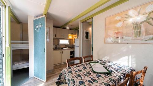 a dining room with a table and a kitchen at Elba Travels in Capoliveri