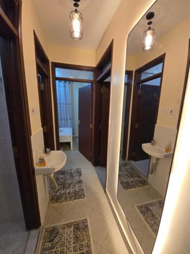 a bathroom with two sinks and two mirrors at Mina Luxe Machakos in Machakos
