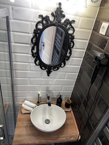 a bathroom with a sink and a mirror on the wall at Petőfi Sarok Apartman in Keszthely