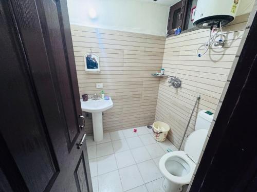 a small bathroom with a toilet and a sink at Homely stayy in Mohali