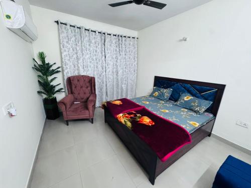 a bedroom with a bed and a chair at Homely stayy in Mohali