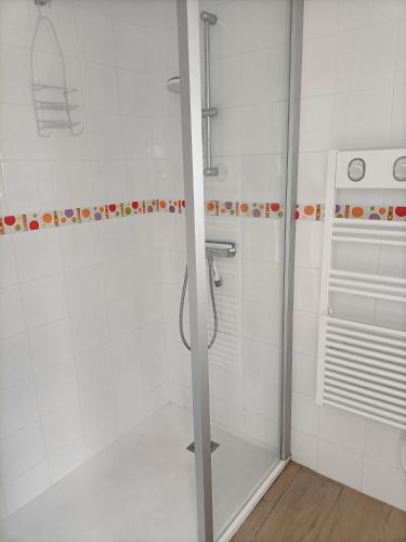a shower in a bathroom with white tiles at Agréable studio indépendant proche mer in Saint-Hilaire-de-Riez
