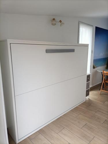 a large white counter in a room with a table at Agréable studio indépendant proche mer in Saint-Hilaire-de-Riez