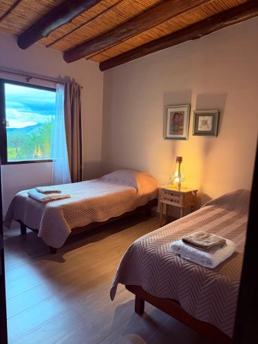 a bedroom with two beds and a window at Barcena Houses in Tumbaya
