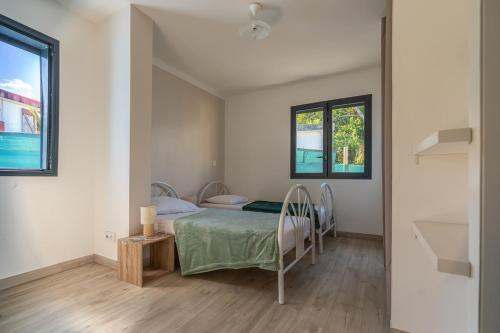 a bedroom with a bed and a window at Villa Coeur Bleu in Petit-Bourg