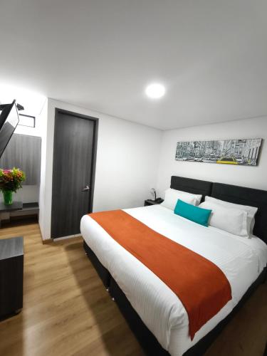 a bedroom with a large bed in a room at Hotel Portal de los Andes in Bogotá