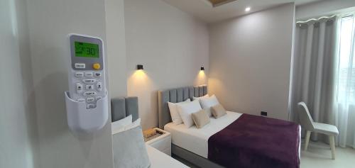 a hotel room with a bed and a remote control at RADIO HOTEL Lushnje in Lushnjë