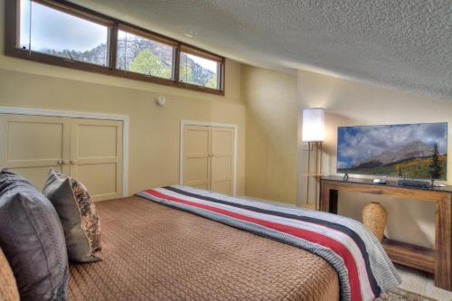 a bedroom with a bed with a fireplace and a tv at Tamarron Lodge Loft 510 in Durango