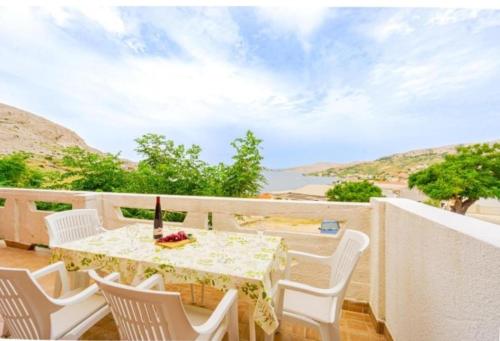 a table and chairs on a balcony with a view at Sea & Mountain View Apartments - Metajna in Metajna