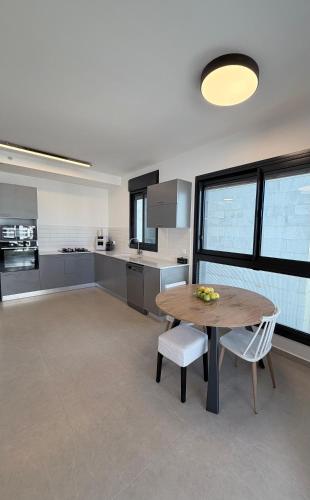 a large kitchen with a wooden table and chairs at Bat Yam apartment in Bat Yam