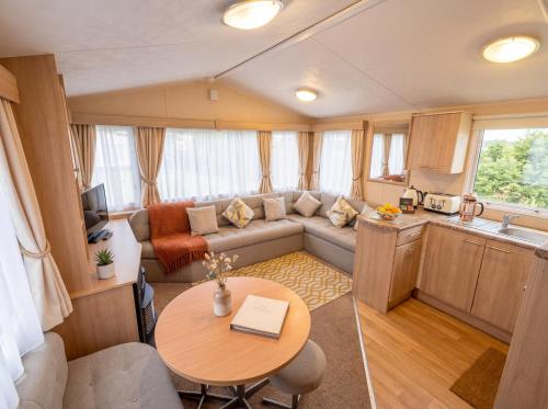 a living room with a couch and a table at Blue Curlew in Scratby