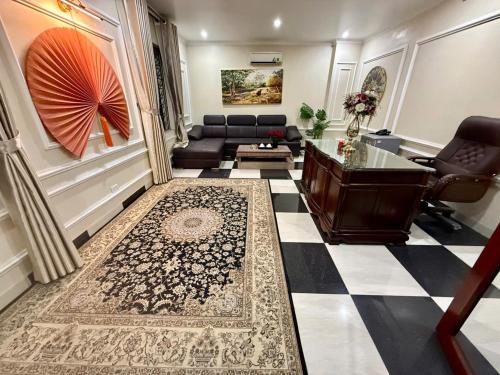 a living room with a couch and a desk at hotel phúc khánh in An Dương