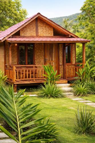 a house with a porch in the middle of a yard at Ocean Fresh Surfhouse in Pulau Sarang
