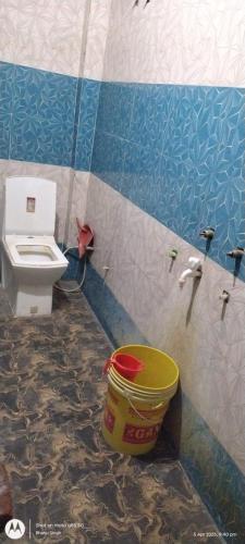 a bathroom with a toilet and a bucket at Sai holidays in Ayodhya