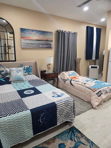 two beds in a bedroom with blue curtains at Coastal Escape Walkable, Cozy Pet-Friendly in Jacksonville Beach