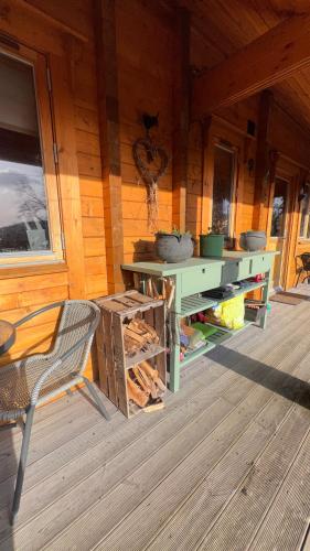 a wooden cabin with a table and a chair on a deck at Blossom Cabin - Little log Cabin in Wales in Newtown
