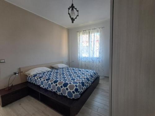 a bedroom with a bed with a blue and white comforter at Il Nido di Chiara 2 in Formia