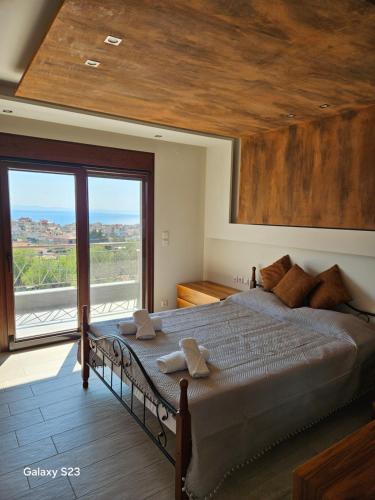 a bedroom with a large bed with a large window at Moumis Luxury Apartment in Limenaria
