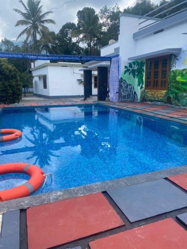 a swimming pool in front of a house at W Villas in Padinjarathara