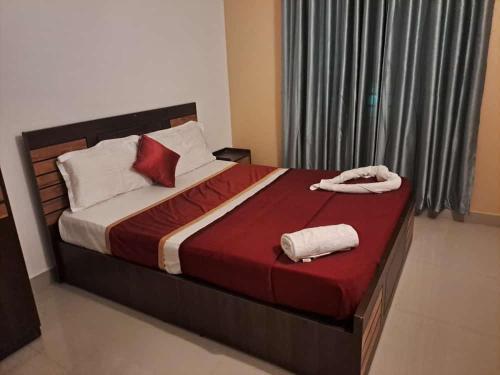 a bedroom with a bed with two towels on it at W Villas in Padinjarathara