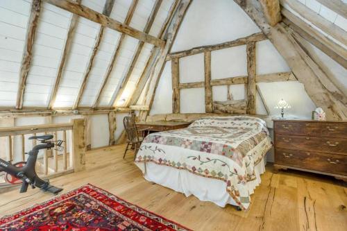 a bedroom with a bed and a desk in a attic at Unique Luxury Barn in Tenbury