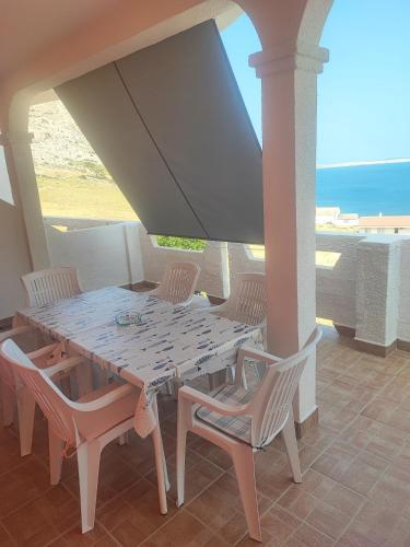 a table and chairs on a porch with the ocean at Sea & Mountain View Apartments - Metajna in Metajna