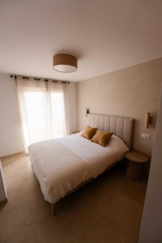 a bedroom with a large white bed with two pillows at NUMA Beach Apartments in Aguadulce