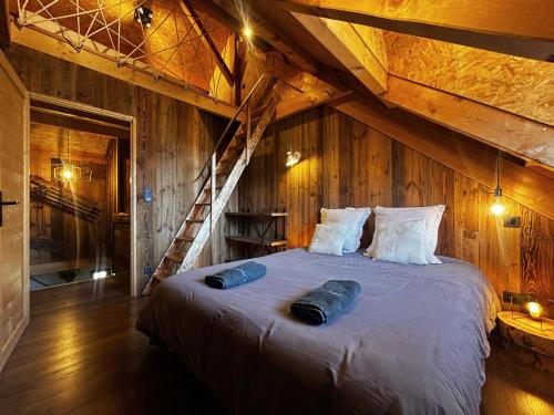 a bedroom with a large bed in a attic at Le chalet des fontaines in Allos