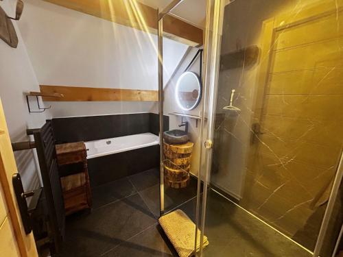 a bathroom with a shower and a bath tub at Le chalet des fontaines in Allos