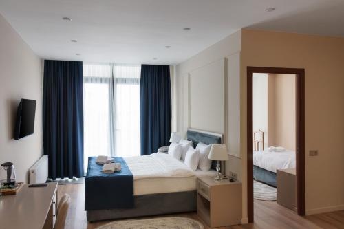 a bedroom with a large bed and a mirror at Podium Boutique Hotel in Yerevan