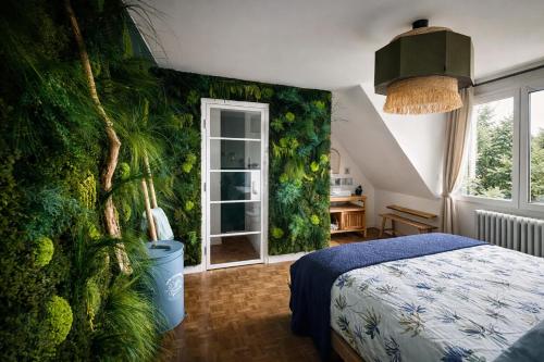 a bedroom with a green wall with a bed and a window at B&B Villa Marie-Lou in Le Portel