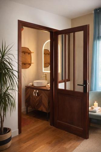 a bathroom with a wooden door and a sink at B&B Villa Marie-Lou in Le Portel