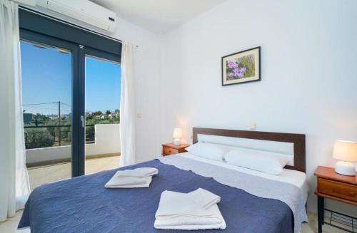 a bedroom with a large bed with towels on it at Scandia Villas in Potos