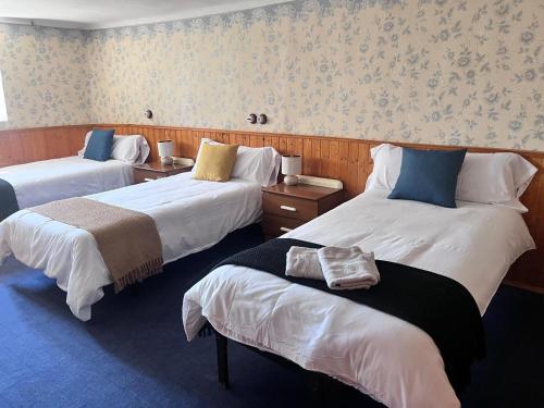 a hotel room with three beds in a room at Navas de Lema in Las Navas de Buitrago