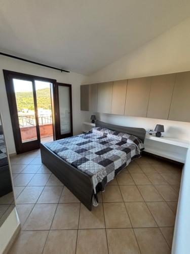 a bedroom with a bed in a room with a window at Casetta Alamar in San Teodoro