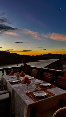 a dinner table with a view of the ocean at sunset at Villa Diomira in Cannobio
