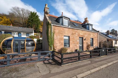 a house with a van parked in front of it at Shore View Cottage in Inverness