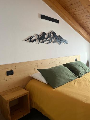 a bedroom with a bed with a mountain on the wall at Mansarda Mitta Coel in Torre di Santa Maria