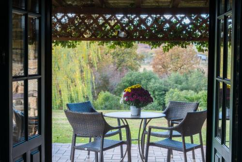 a patio with a table with chairs and a vase of flowers at Platanorema in Agios Ioannis Prodromos